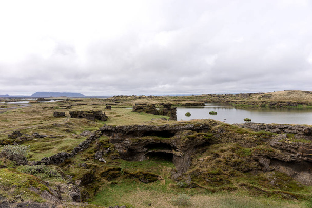 A különböző vulkáni sziklaalakzatok Izlandon Myvatn-tó látképe - Fotó, kép