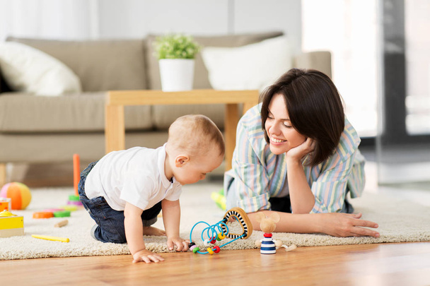 happy mother with little baby son playing at home - 写真・画像