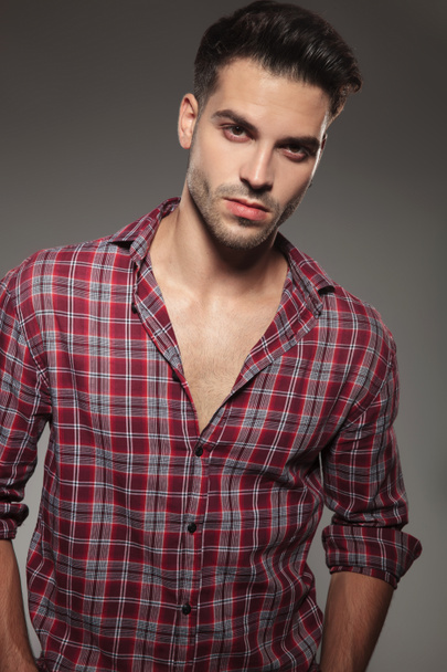 kockás ing, pózol a szürke háttér alkalmi fiatalember portréja - Fotó, kép