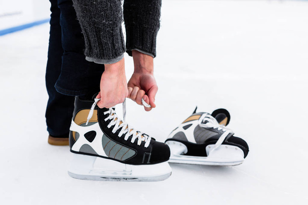 Mains attachant chaussures de patinage dentelle
 - Photo, image