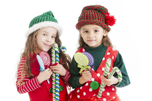 Two lIttle christmas elves hold candy canes and suckers - Φωτογραφία, εικόνα