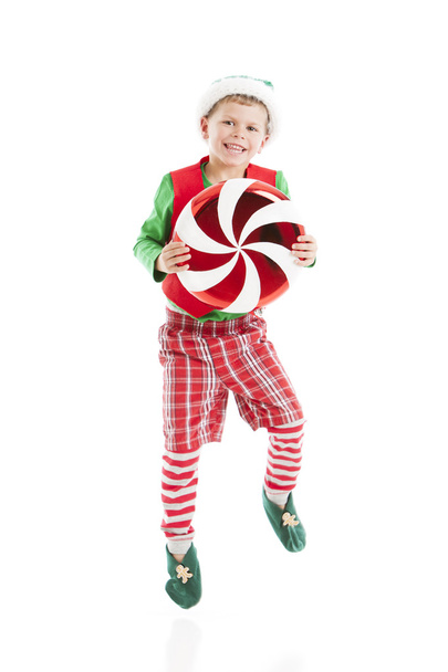 One of Santas сhristmas elves dances with a large candy peppermint. - Foto, Imagem