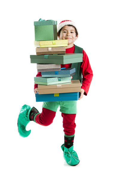 A hispanic elf dances a jig while carrying a tall stack of christmas presents - Φωτογραφία, εικόνα