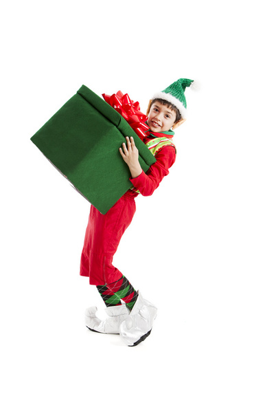 A Hispanic elf, struggles with a big, heavy Christmas present. - Photo, Image