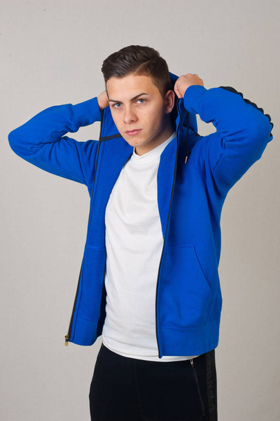 Jovem vestindo roupas esportivas azuis no estúdio
 - Foto, Imagem