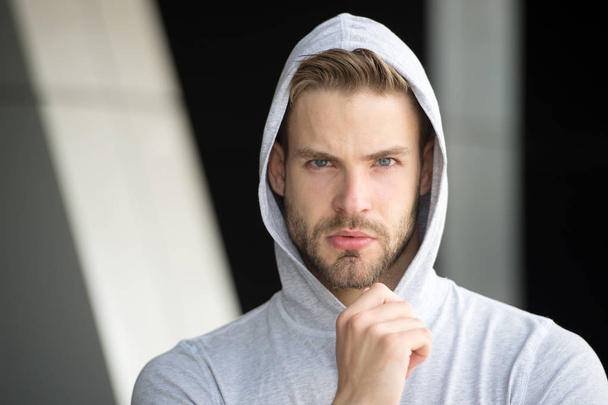 Focused future achievement. Guy bearded attractive casual clothes hooded. Man with bristle concentrated face urban background defocused. Man unshaven guy looks handsome hooded. Concentrated on goal - Valokuva, kuva