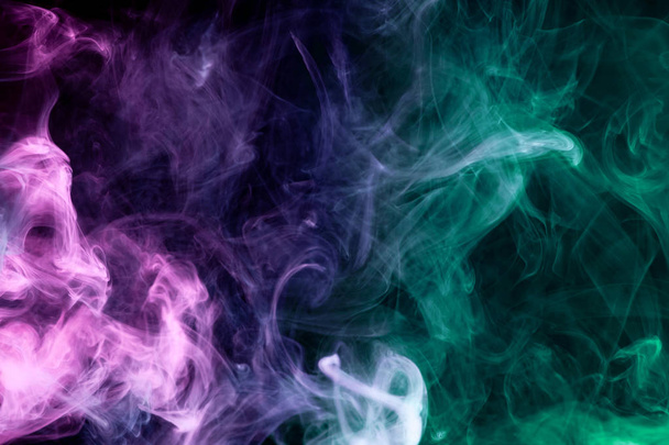 Cloud of pink, red and blue smoke on a black isolated background. Background from the smoke of vap - Photo, Image