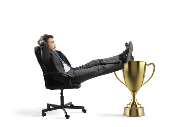 Gewinner Geschäftsmann entspannt bei einem goldenen Pokal - Foto, Bild