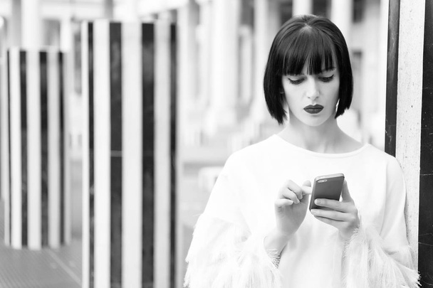 New technology for modern life. Woman with red lips use on smartphone in paris, france. Woman with brunette hair hold mobile phone. Beauty girl with sexy look. Fashion model with mobile device - Foto, imagen
