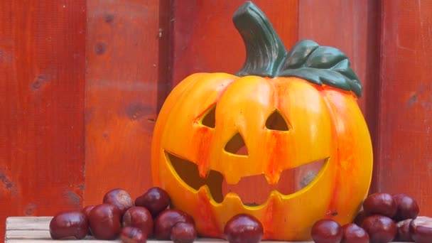 Halloween Pumpkin od drewniane tła z kasztanów - Materiał filmowy, wideo