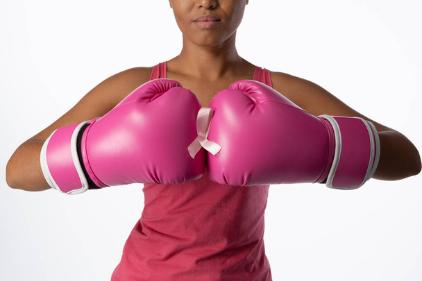 Pysyvä nainen rintasyövän tietoisuutta nauha ja nyrkkeily käsineet valkoisella pohjalla
 - Valokuva, kuva