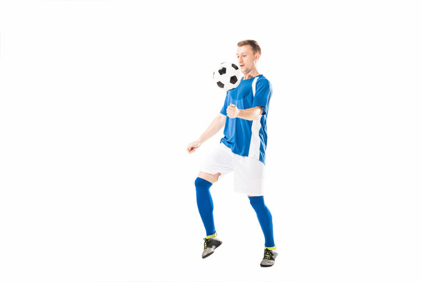 full length view of athletic young soccer player training with ball isolated on white  - Fotoğraf, Görsel