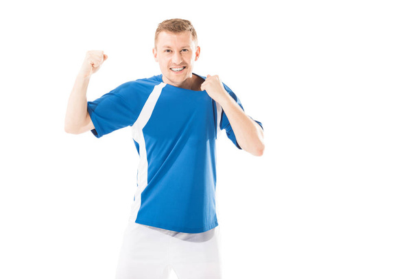 excited young sportsman triumphing and smiling at camera isolated on white - Fotó, kép
