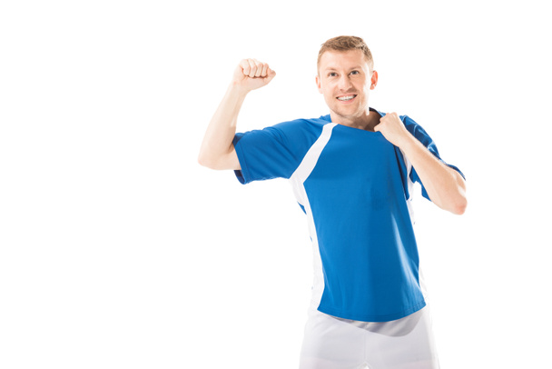 triumphing young sportsman shaking fist and smiling isolated on white - Foto, Imagem