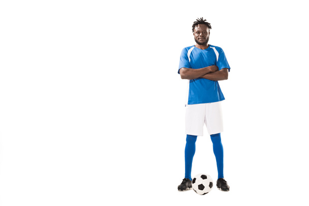 confiado jugador de fútbol afroamericano de pie con los brazos cruzados y mirando a la cámara aislada en blanco
  - Foto, imagen