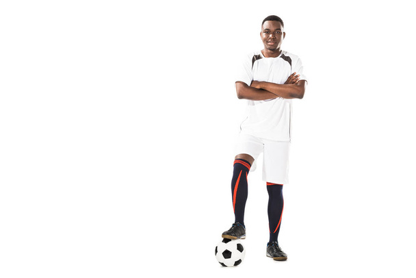confiante jovem jogador de futebol americano africano de pé com braços cruzados e sorrindo para a câmera isolada em branco
 - Foto, Imagem