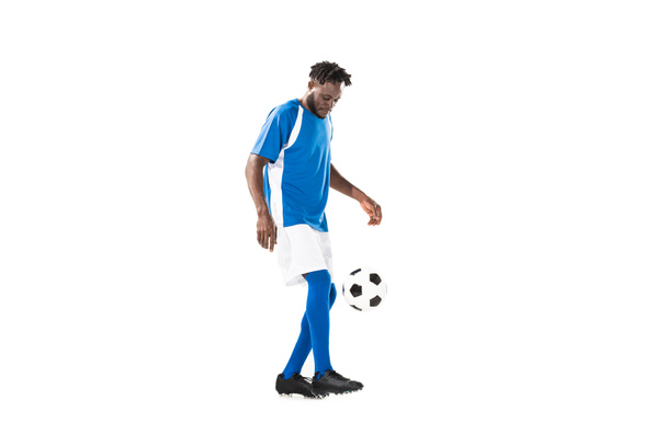 side view of african american sportsman playing with soccer ball isolated on white - Фото, изображение