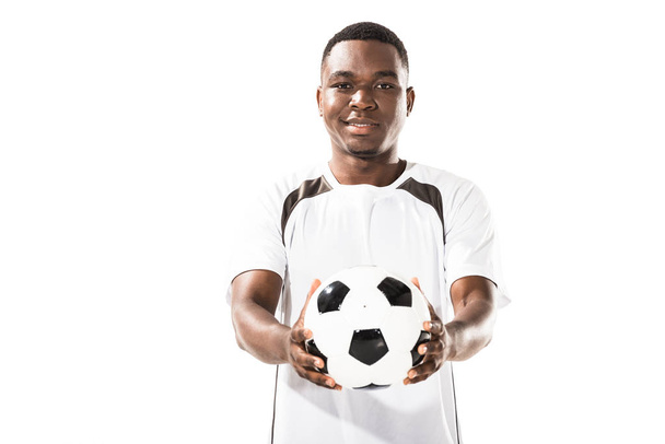handsome happy young african american sportsman holding soccer ball and smiling at camera isolated on white - Photo, Image