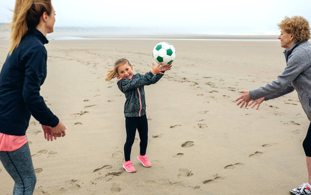 Tre generazioni di donne che giocano sulla spiaggia
 - Foto, immagini