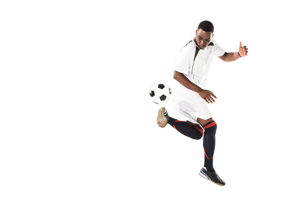 full length view of athletic african american soccer player kicking ball isolated on white  - Fotografie, Obrázek