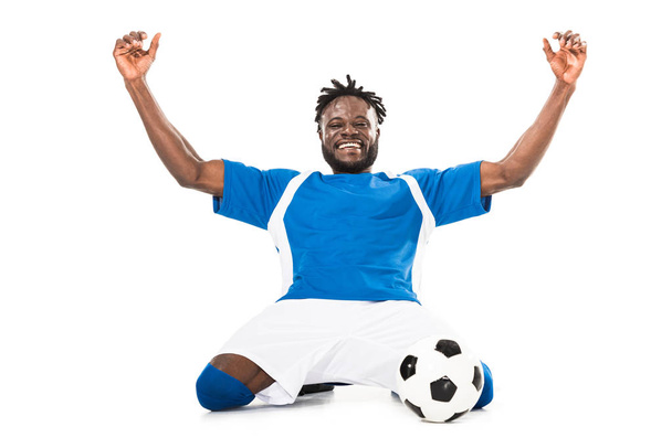 excited african american soccer player triumphing and raising hands isolated on white - Photo, Image