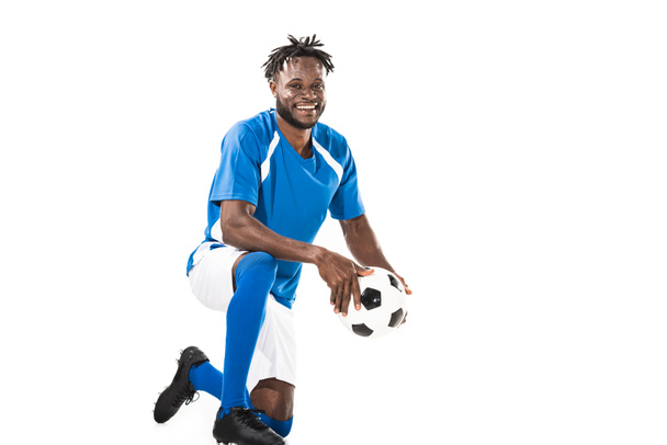 cheerful young african american soccer player holding ball and smiling at camera isolated on white - Photo, Image