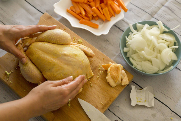 женские руки готовят сырую курицу на деревянной доске, крупным планом
  - Фото, изображение