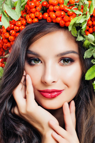 Morena mulher rosto closeup retrato de moda. Maquiagem lábios vermelhos, sorriso bonito, bagas rowan e folhas verdes
 - Foto, Imagem