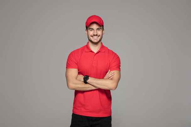 Delivery Concept - Smiling Caucasian courier man posing on studio background. - Foto, Imagen
