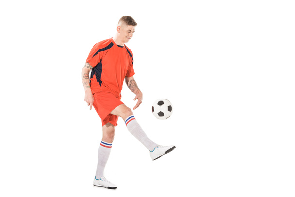 visão comprimento total de sorrir jovem desportista chutando bola de futebol isolado no branco
  - Foto, Imagem