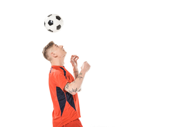 молодий футболіст вдаряє м'яч з головою і дивиться вгору ізольовано на білому
  - Фото, зображення