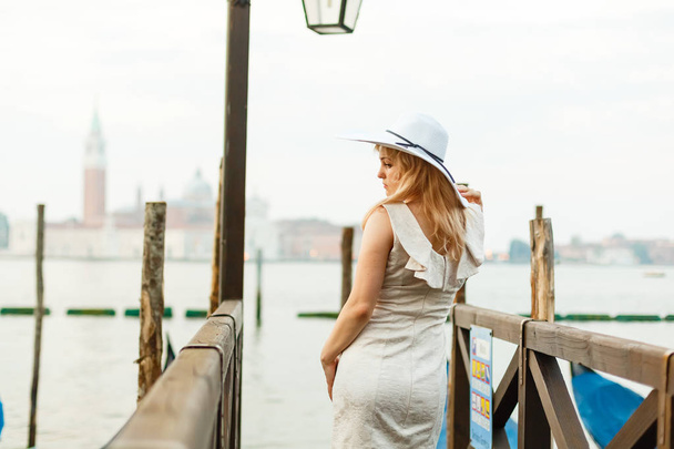 Young woman in white elegant dress posing in Venice at sunrise - Fotoğraf, Görsel