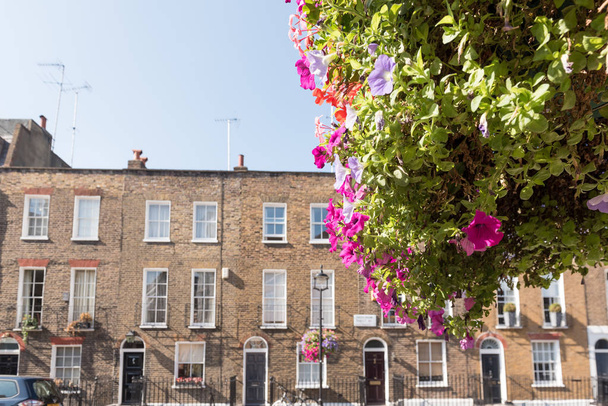 Első homlokzatok és a történelmi tégla London teraszos házakat biztosít magas windows és vas korlát kint egy kerékpár a járdán, és a lámpaoszlop, boltíves ajtók - Fotó, kép