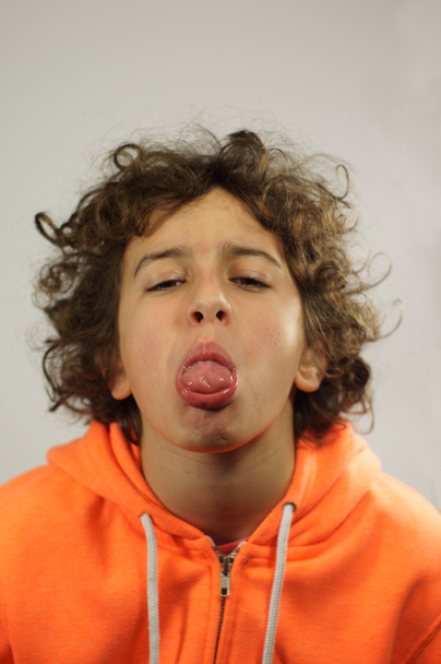 jongen steekt zijn tong uit - Foto, afbeelding