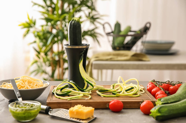 Spiralizer with zucchini noodles and vegetables on kitchen table - Photo, Image