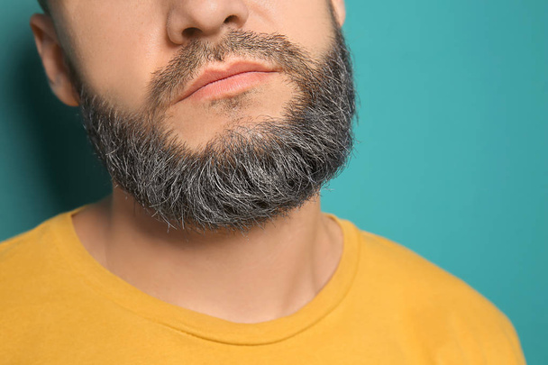 Handsome man with dyed beard on color background, closeup - Foto, afbeelding