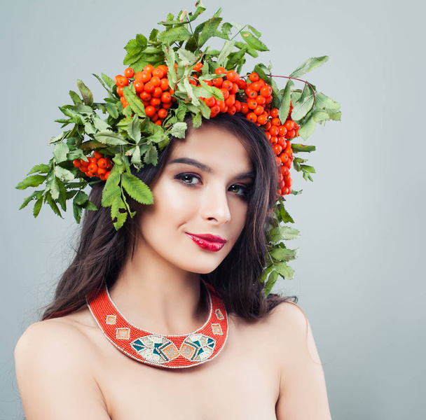 Beautiful woman in fashion jewelry necklace and rowan wreath - Photo, Image