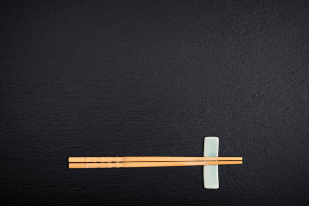 Bamboo chopsticks with copy space on black slate background, top vie - Photo, image