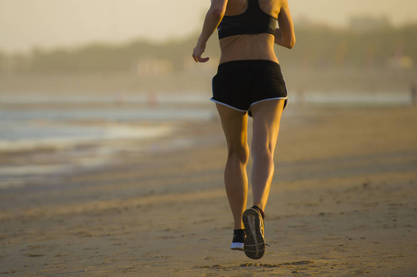 Rückenansicht Beine Detail der jungen glücklichen und attraktiven, fitten Frau, die am Strand joggt, im Freien Jogging-Workout im Fitnesstraining und gesundem, sportlichem Lifestyle-Konzept - Foto, Bild