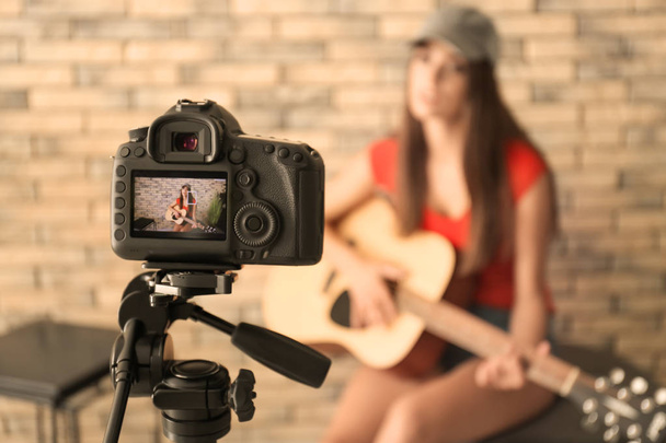 Young female musician recording video indoors - Фото, изображение