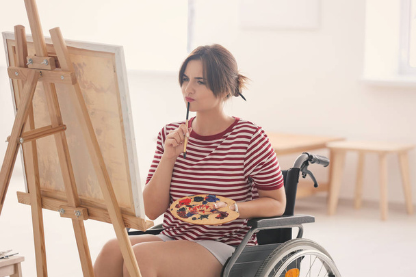 Jovem artista feminina em cadeira de rodas pintura imagem em casa
 - Foto, Imagem