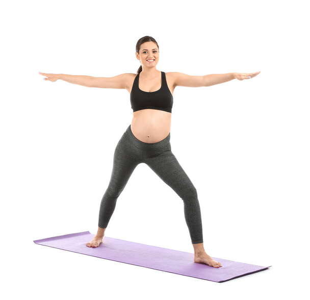 Młoda ciężarna kobieta ćwiczy jogę na białym tle - Zdjęcie, obraz