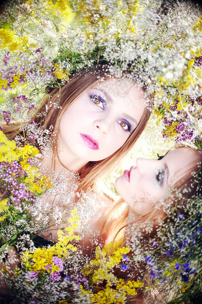 Uma menina em uma grinalda de flores de campo
 - Foto, Imagem