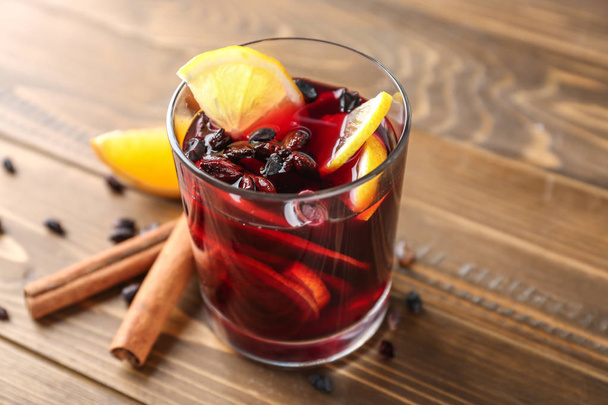 Glass of delicious mulled wine on wooden table - Fotografie, Obrázek