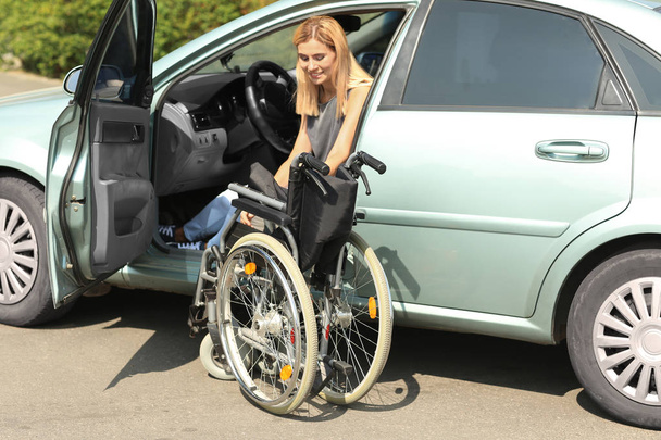 障害を持つ女性が彼女の車から降りて - 写真・画像