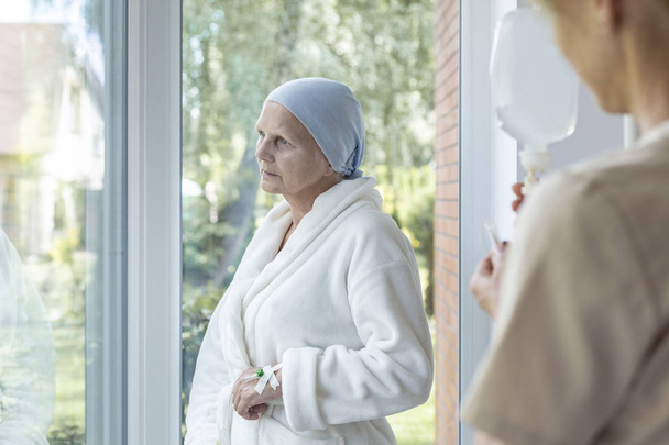 Worried sick senior woman with cancer during treatment in a nursing house - 写真・画像