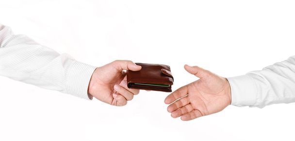 Male hand holding a wallet and handing it over to another person - Valokuva, kuva