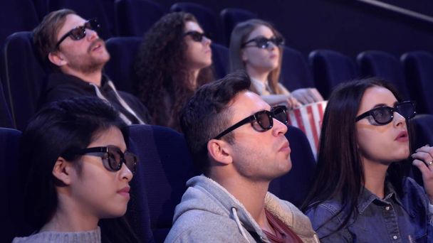 Ihmiset nauttivat 3D-tehosteita elokuvateatterissa
 - Valokuva, kuva