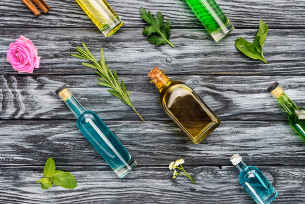 joukko värillisiä pulloja luonnon kasviperäisiä eteerisiä öljyjä puupinnalla
 - Valokuva, kuva
