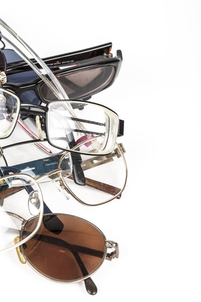Old used eye reading glasses speclacles stacked in a pile on a white background. Place to write - Foto, Imagen